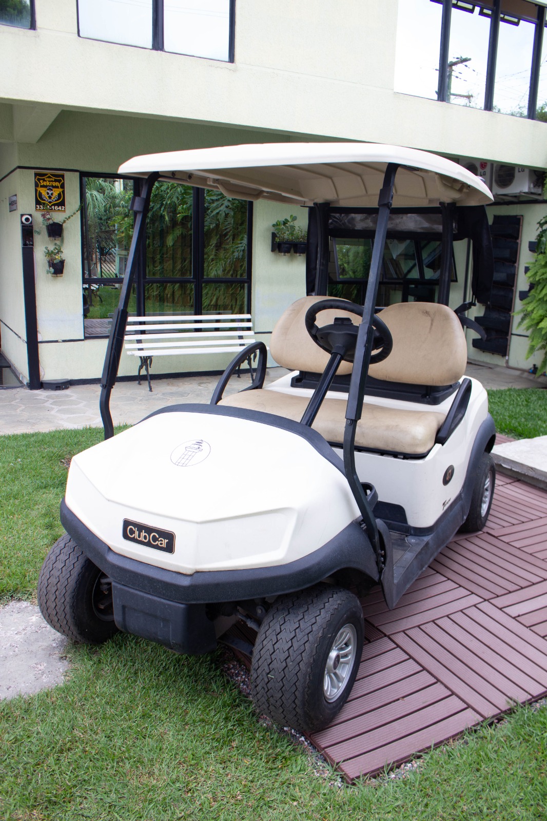 A parked golf cart captured in black and white against an urban wall background.